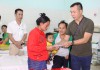 Xạ thủ Hoàng Xuân Vinh tặng quà chị Hồ Thị Xăng-người dân tộc Vân Kiều ở huyện Hướng Hóa có con nhỏ đang được điều trị bệnh tại phòng Cấp cứu của khoa Nhi, Bệnh viện Đa khoa tỉnh Quảng Trị (Ảnh: Lâm Thanh)