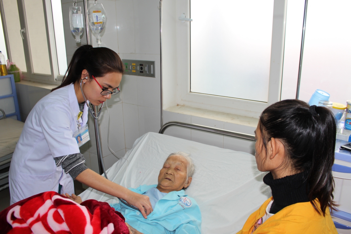 Các y, bác sỹ của Đơn vị Đột quỵ-Bệnh viện Đa khoa tỉnh Quảng Trị chăm sóc sức khỏe cụ bà Đặng Thị Thể sau phẫu thuật động mạch cảnh chung trái (Ảnh: Bội Nhiên)